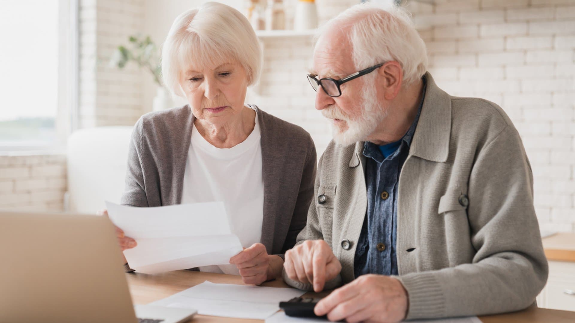 Senior couple reviewing finances at home while weighing reverse mortgage options