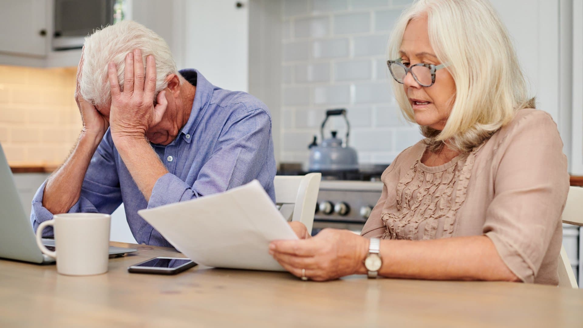 Senior couple reviewing paperwork at home, reflecting a gray divorce refinance buyout